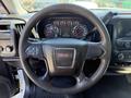 Interior view of a 2016 GMC Sierra 1500 featuring a black steering wheel with the GMC logo and a dashboard with various gauges and controls