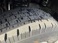Close-up of a tire on a 2011 Ford Econoline showing detailed tread pattern and slight wear on the rubber surface