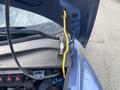 A blue 2007 Chrysler PT Cruiser with its hood open, showcasing the engine compartment and a yellow hood prop rod.