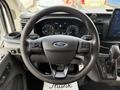 A steering wheel of a 2022 Ford Transit with controls on either side and a Ford logo at the center