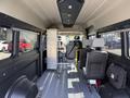 Interior view of a 2021 RAM Promaster displaying seats along one side and storage equipment along the opposite side with a clear aisle in between