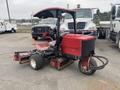 A red 2011 Toro Reelmaster 3100-D turf maintenance machine with a steering wheel and large rear tires designed for mowing grass.