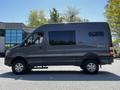 A 2017 Mercedes-Benz Sprinter van with a dark gray exterior and large windows, viewed from the side showing its sleek design and high roof