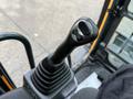 A close-up of the joystick control for a 2022 Hyundai R55-9A excavator featuring a textured grip and a button on top