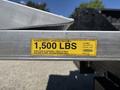 A close-up of a warning label on a tailgate indicating a maximum capacity of 1500 lbs for lifting and lowering loads
