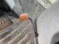 A close-up view of the foot pedal of a 2016 New Holland T475 tractor showing an orange and black striped design on a metallic lever