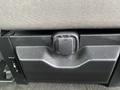 A close-up of a storage compartment in the rear seat of a 2019 Ford F-150 with a latch mechanism and textured surface