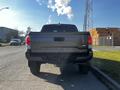 A 2021 Toyota Tacoma viewed from the rear showing its tailgate and rear bumper with the Tacoma logo prominently displayed