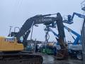 A 2014 John Deere 350G excavator with a large arm and bucket attachment positioned for operation