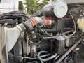 Close-up of the engine compartment of a 1996 Kenworth T800 showing various components including hoses pipes and an air filter