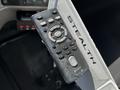 A worn Sony remote control with various buttons and a prominent central "Enter" button held against a metallic surface labeled "STEALTH"