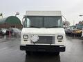 A 2012 Ford Econoline van facing forward with a white exterior and a simple design featuring a rectangular grill and two headlights