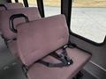 Interior view of a 2014 Ford E-350 showing a single maroon seat with a seatbelt attached, positioned next to a window