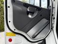 Interior door panel of a 2010 Freightliner M2 106 featuring a gray design with a handle and padded armrest
