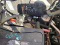 A 2020 Chevrolet Express van engine with visible battery connections and wiring located in the foreground