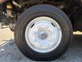 Close-up of a white wheel rim with six bolts and a black tire labeled R228 mounted on a 2019 Freightliner MT45