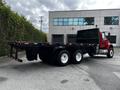A red 2011 International 4400 flatbed truck with a black cargo area and dual rear wheels positioned at a slight angle