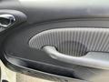 Close-up of the interior door panel of a 2005 Chrysler PT Cruiser featuring a textured fabric insert and a door handle
