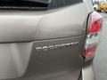 A rear view of a 2016 Subaru Forester showing the model name "FORESTER" in chrome lettering on the tailgate with water droplets on the surface