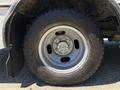 Close-up of a wheel and tire from a 2020 Chevrolet Express showing a silver rim with five lug nuts and a black treaded tire