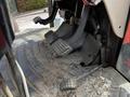 Close-up view of the foot pedals of a 2011 Kubota M8540D tractor showing the accelerator and brake pedals along with worn rubber mats