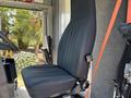 The image shows the driver's seat of a 2019 Freightliner MT45 an adjustable black seat with vertical stitching positioned inside the vehicle cabin