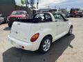 A white 2005 Chrysler PT Cruiser convertible with a black soft top parked with its rear facing the viewer