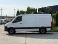 A white 2021 Mercedes-Benz Sprinter van with a long body and a black stripe along the bottom is parked with its side visible