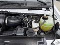 Engine compartment of a 2019 Ford Econoline showing the air intake system coolant reservoir and various engine components