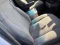 The front passenger seat of a 2016 GMC Savana with gray fabric upholstery featuring a contoured design and a console between the seats