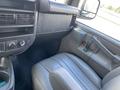 Interior view of a 2023 GMC Savana showing the driver's side seat and dashboard area with controls and storage compartments
