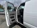 A 2009 Ford Econoline van with the driver's side door open, showing the interior and dashboard details