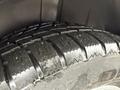 Close-up of a textured tire from a 2017 Dodge Grand Caravan showing deep tread patterns and slight wear on the rubber surface