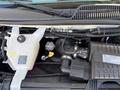 The engine compartment of a 2017 Chevrolet Express showing the cooling system reservoir and various engine components including hoses and tubes