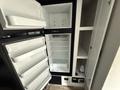 A 2022 Keystone Hideout RDWE 20RDWE refrigerator with an open door showing empty shelves and storage compartments inside