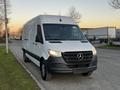 A 2019 Mercedes-Benz Sprinter van with a white exterior and black grille parked on a road