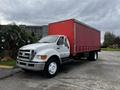 White 2008 Ford F-750 truck with a red cargo box parked in the foreground