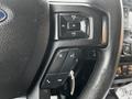 Steering wheel controls of a 2016 Ford F-150 featuring audio volume buttons and a phone operation button