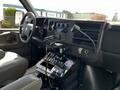 Interior view of a 2013 Chevrolet Express with a steering wheel touchscreen display and various control buttons mounted on the dashboard