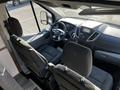 Interior view of a 2017 Ford Transit showing two front seats and a dashboard with a display screen and various controls