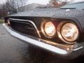 A 1974 Dodge Challenger with a sleek black body and chrome front grille featuring the name Challenger illuminated headlights and a shiny bumper