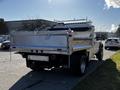 A 2008 Ford F-450 SD with a flatbed body and chains attached to the rear, showcasing its utility design and sturdy build