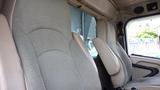 Interior of a 2003 International 5600i featuring two plush, high-backed seats in a light gray upholstery