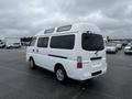 A white 2002 Nissan Van with a distinctive rounded roof and rear windows parked in a lot