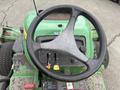 Close-up view of the steering wheel and control panel of a 2009 John Deere 2653B Precision Diesel Mower with visible switches and levers