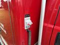 A quartz light switch mounted on the side of a red fire truck with a coiled cord attached