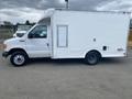 A 2004 Ford Econoline van with a boxy white cargo section and a single side window on the driver's side