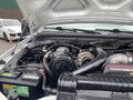 The image shows the engine compartment of a 2003 Ford F-450 SD featuring an engine, battery and various automotive components including belts and tubes
