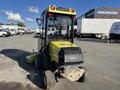 A yellow and black 2010 Kubota F3990 mower with a cab and rear engine visible parked on a lot