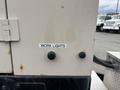 A metal panel from a 2005 Katolight SED60FPJ4 generator features a label reading WORK LIGHTS above two black control switches